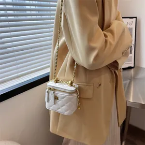 White quilted mini crossbody bag with camellia detail and gold chain strap for women
