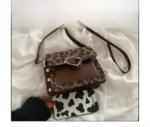 Dettaglio borsa a tracolla leopardata con fibbia metallica e borchie quadrate decorative
