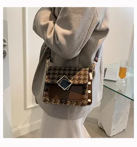 Dettaglio di una borsa a tracolla vintage con motivo leopardato e chiusura geometrica oro