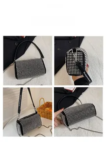 Detail of black cylindrical bag featuring silver studs and elegant chain strap