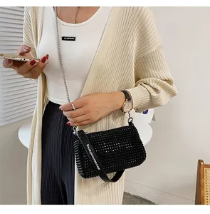 Detail of black rhinestone cylinder bag with shiny crystals and trendy wide shoulder strap