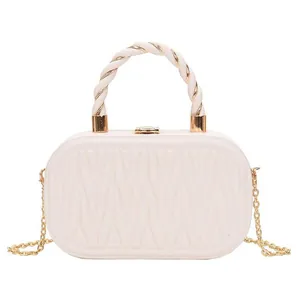 White matelassé box clutch with gold hardware and elegant twisted rope top handle