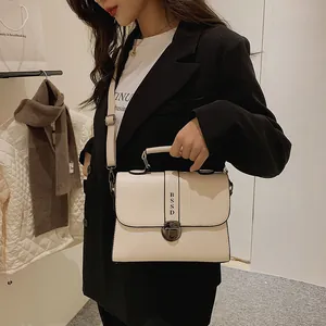 Chique beige crossbody tas in vierkante vorm met vintage slot en brede schouderriem