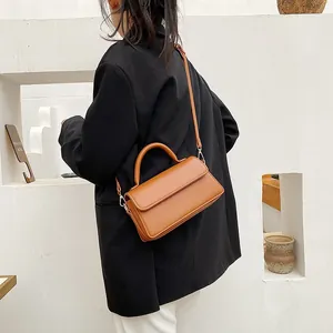 Petit sac bandoulière marron caramel porté par un mannequin sur fond blanc épuré