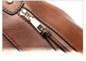 Detailaufnahme der braunen Handtasche aus Leder mit litchi-Maserung und goldenem Zipper