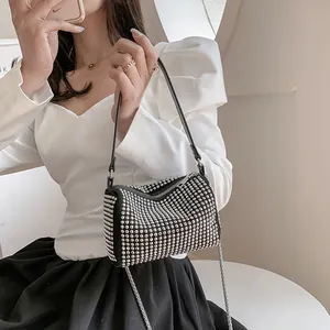 Fashionable black cylindrical handbag with silver studs and chain strap on model