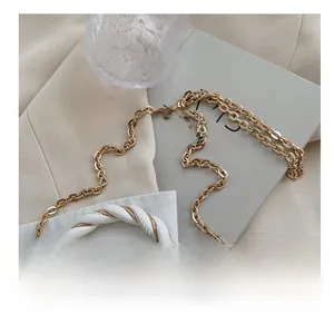 Detail of white leather braided handle with golden metal chain on a crossbody bag