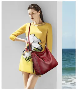 Detail einer tiefroten Hobo-Tasche aus Leder mit goldenem Reißverschluss und Quaste