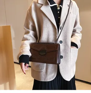 Détail du sac bandoulière matelassé marron foncé avec chaîne en métal et rivets