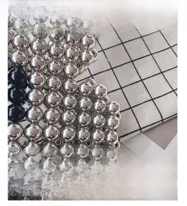 Macro shot of silver metallic beads and black accents on a hand-woven fashion bag