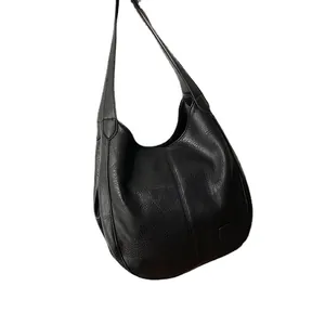 Bolso tipo cubo retro de cuero negro con textura lichi y correa de hombro ancha