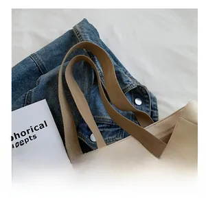 Detail view of reinforced canvas tote handles with soft fabric texture and durable stitching