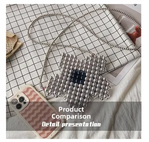 Size comparison of silver beaded flower crossbody bag with smartphone on grid background