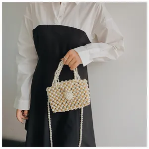 Detailed macro view of handmade pearl beaded handbag with floral buckle and elegant strap