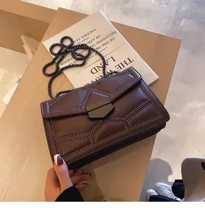 Détail du sac matelassé marron foncé avec rivets, bandoulière chaîne et fermoir métal