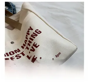 Detailed view of heavy-duty canvas tote stitching and red graphic typography