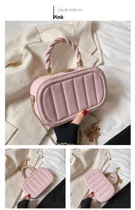 Detail of pink evening bag with vertical stripes, gold chain, and twisted leather handle
