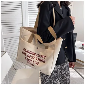 Canvas tote bag in beige with red lettering and brown handles for daily fashion