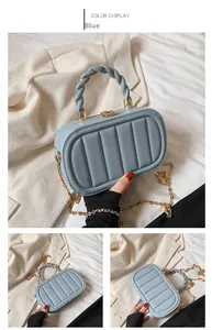 Detail of blue quilted handbag with braided handle and gold metal chain strap
