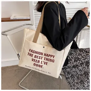 Close-up of cream canvas tote bag with brown straps and stylish bold typography details
