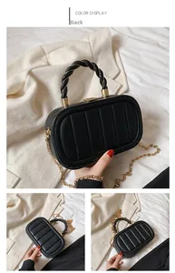 Detail of black crossbody bag with vertical stitching and woven spiral handle