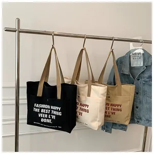 Three canvas tote bags in black beige and khaki hanging with stylish letter prints