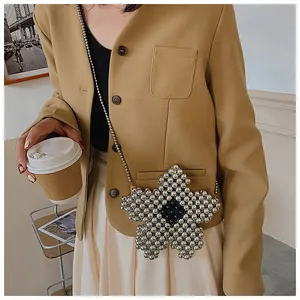 Detail of star-shaped beaded crossbody bag with silver metallic beads and black floral core