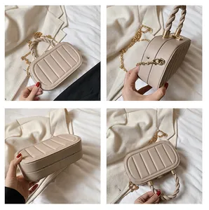 Detail view of beige crossbody bag with quilted stripes, braided handle and gold chain