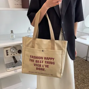 Large beige canvas tote bag with front snap pocket and letters for daily casual use