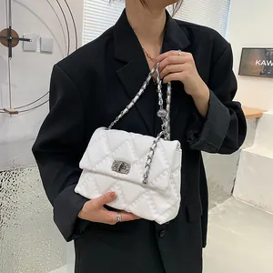 White quilted crossbody bag with silver chain strap and metal lock closure for women