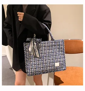 Close-up of blue plaid tweed tote bag featuring a decorative Paris silk bow and white label