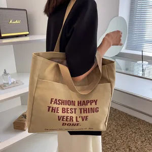 Large capacity apricot canvas tote bag with retro lettering shown on a model