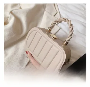 Detail of beige structured handbag with vertical stripes and woven handle