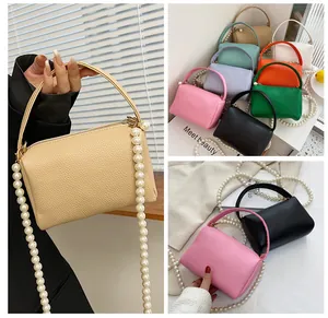 Détail du mini sac à main en cuir souple avec chaîne en perles et texture grainée