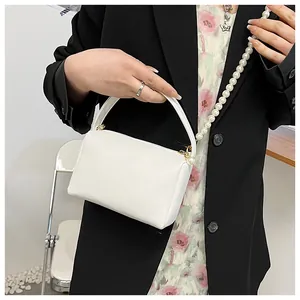 Détails du sac blanc en cuir grainé avec chaîne en perles et fermoir en métal doré