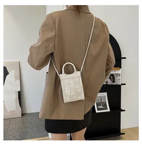 Chic cream woven mini bag shown with a brown blazer on a model for a modern look