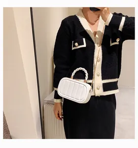 Close-up of white quilted handbag with woven handle and gold chain strap on model