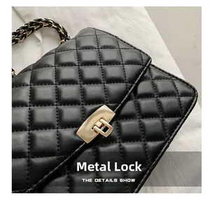 Détail du sac bandoulière matelassé noir avec fermoir rotatif doré et chaîne