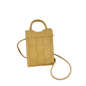 Woven small crossbody phone bag in mustard yellow leather with a top handle and strap