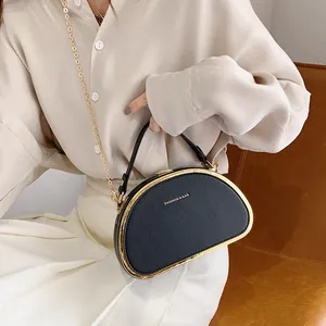 Chique zwarte halfronde crossbodytas met gouden metalen rand en handvat bovenop