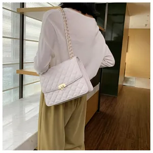 Détail du sac à main matelassé blanc avec fermoir doré et bandoulière en chaîne