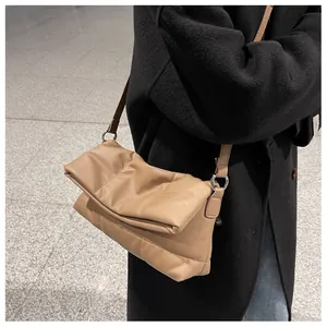 Detalle del bolso de cuero caqui acolchado con textura plisada suave y detalles de la correa
