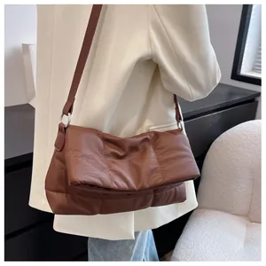 Detalle de bolso bandolera acolchado en piel sintética marrón con correa ajustable