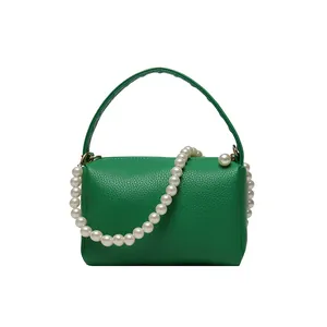 Sac à main cylindre en cuir vert avec chaîne en perles et texture grainée