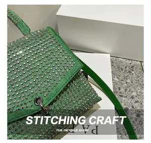 Makrodetail der hochwertigen Nähte und glitzernden Strasssteine an der grünen Handtasche