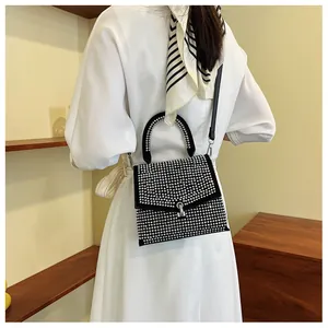 Nahaufnahme einer funkelnden schwarzen Strass-Handtasche, von einem Model getragen