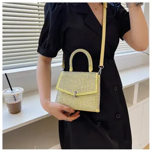 Detail der gelben Mini-Strass-Tasche mit Kristalltextur und Metall-Klappverschluss