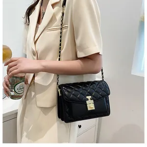 Detail showing black quilted crossbody bag with gold chain and perfume bottle clasp