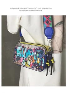 Detailed view of colorful graffiti camera bag with wide patterned strap and tassel zip