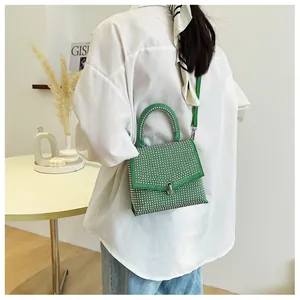 Detailansicht der grünen Strass-Handtasche mit glänzenden Akzenten und Silberbeschlag
